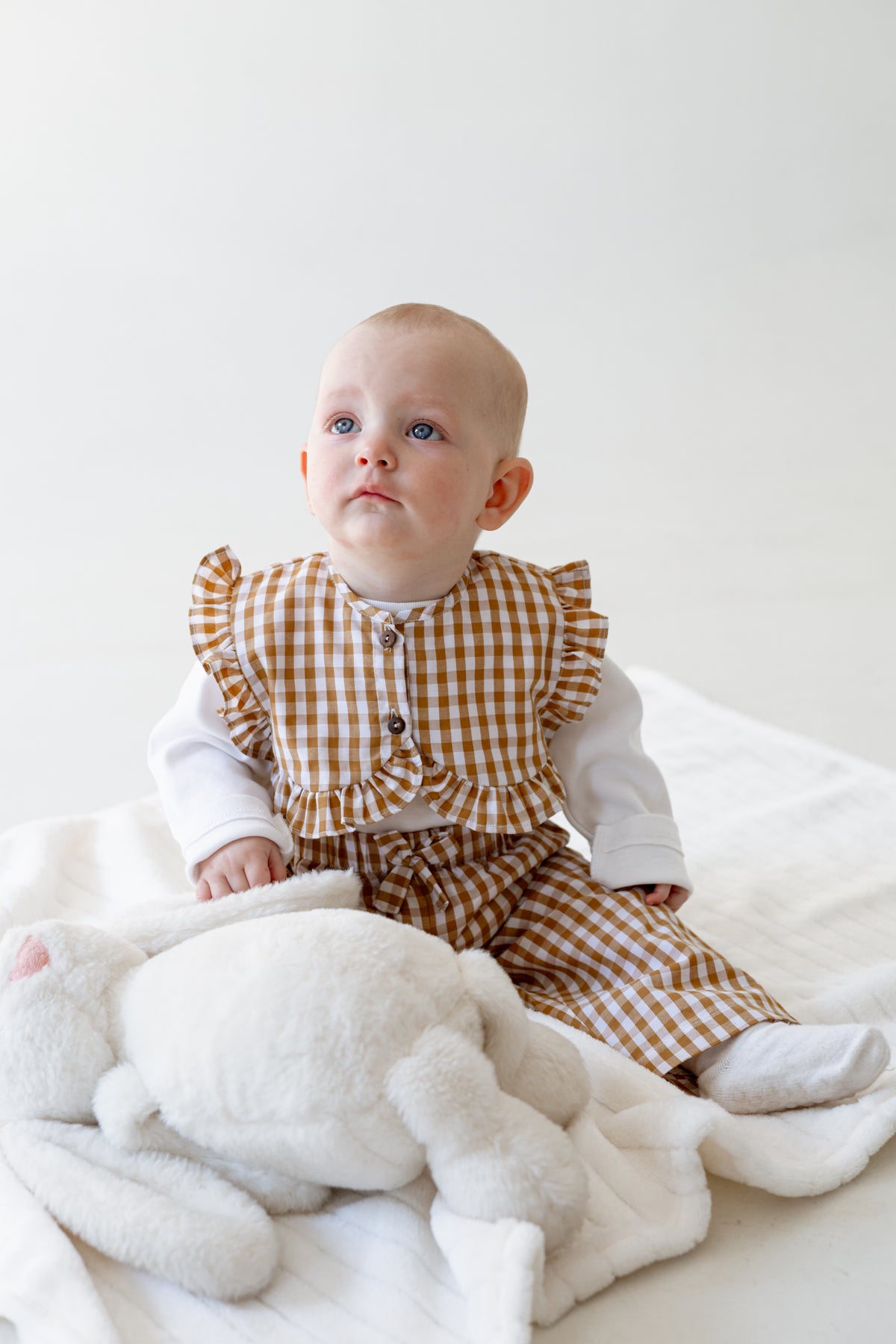 Baby sitting on the floor wearing the Gingham 3-Piece set.
