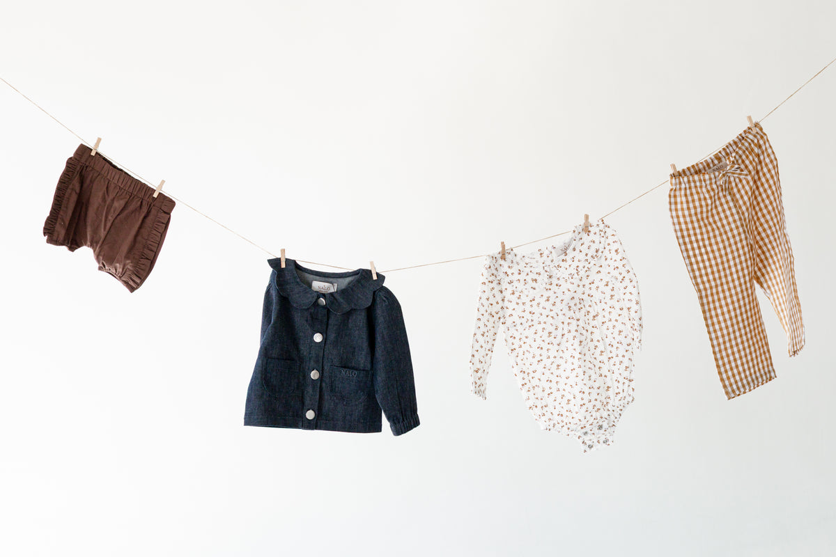 Baby clothes hanging on a washing line.